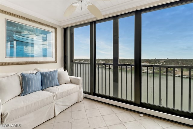 sunroom with ceiling fan and a water view