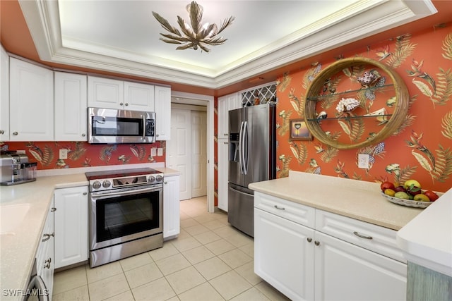 kitchen featuring a chandelier, appliances with stainless steel finishes, white cabinetry, and a raised ceiling