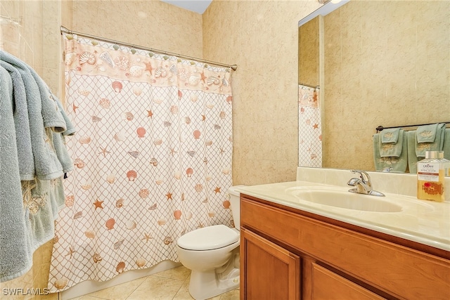 bathroom with toilet, vanity, tile patterned floors, and tile walls