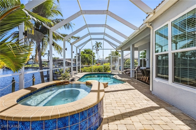 view of pool featuring glass enclosure, a water view, an in ground hot tub, and a patio