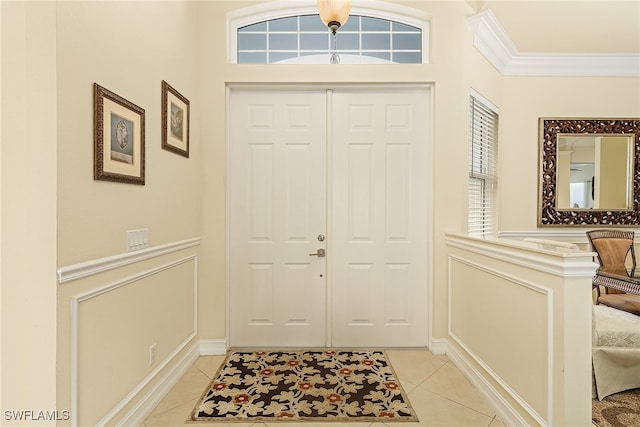 entrance foyer featuring light tile patterned floors and crown molding