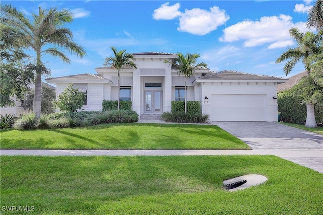 mediterranean / spanish-style house featuring a front yard and a garage