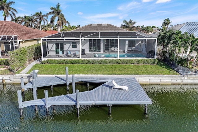 back of property with glass enclosure, a water view, and a yard