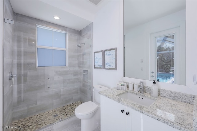 bathroom featuring tile patterned floors, vanity, an enclosed shower, and toilet