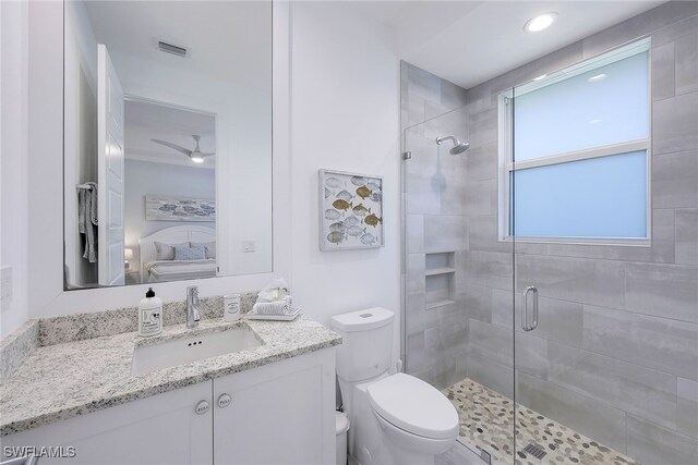 bathroom featuring vanity, toilet, walk in shower, and ceiling fan