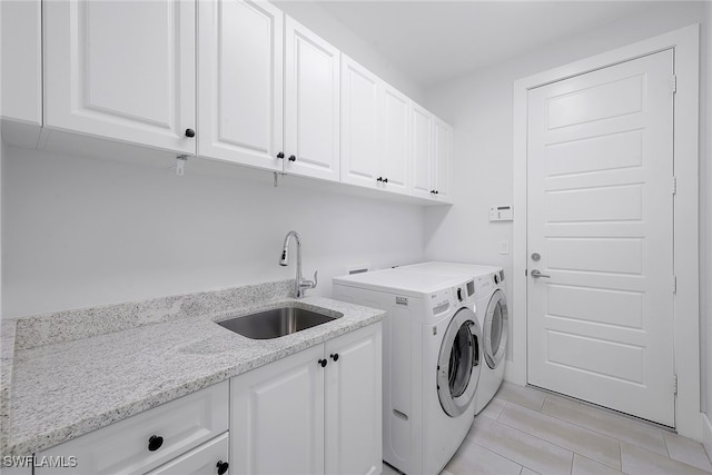 laundry area with washer and clothes dryer, sink, and cabinets