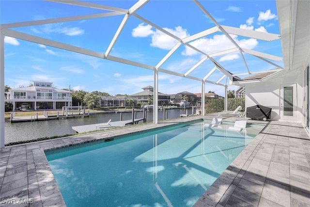 view of pool featuring glass enclosure, a patio area, a dock, area for grilling, and a water view