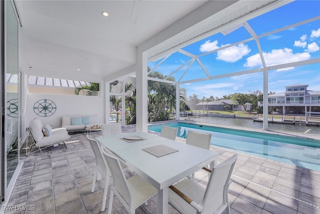 view of swimming pool featuring a lanai, a water view, and a patio