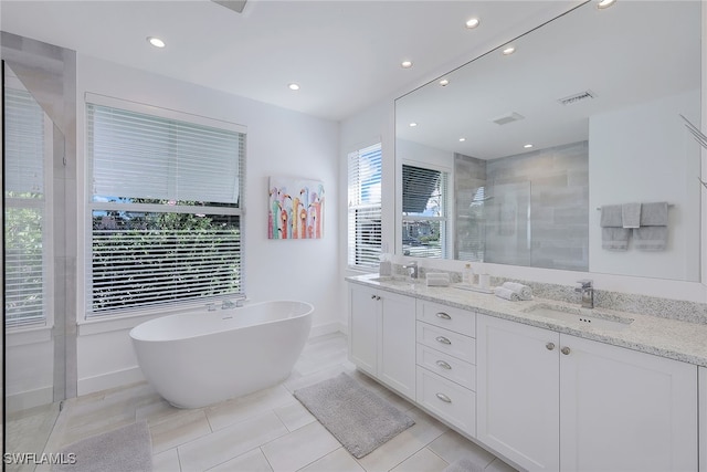 bathroom featuring shower with separate bathtub, vanity, and tile patterned floors