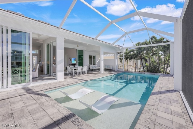 view of swimming pool with glass enclosure, ceiling fan, and a patio