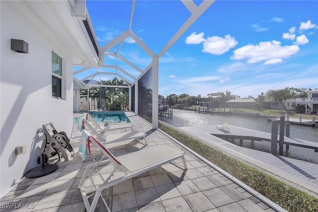 view of patio with a water view, a dock, and glass enclosure