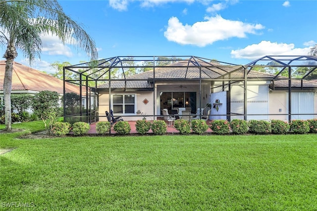 back of house with ceiling fan, a lanai, and a yard