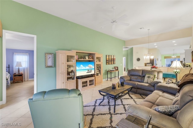 living room with light tile patterned floors and ceiling fan with notable chandelier