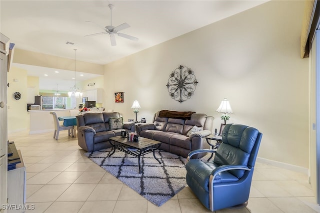 tiled living room with ceiling fan with notable chandelier