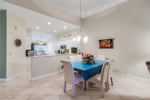 dining room with ceiling fan with notable chandelier, lofted ceiling, sink, and light tile patterned floors