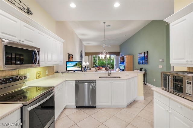 kitchen featuring kitchen peninsula, backsplash, stainless steel appliances, sink, and white cabinets