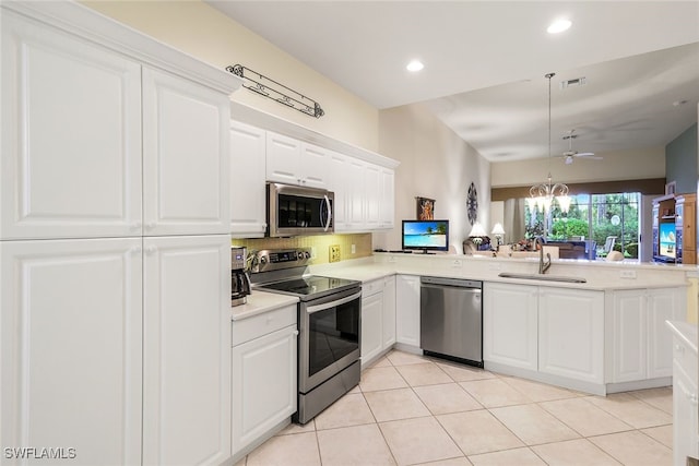 kitchen featuring backsplash, sink, kitchen peninsula, white cabinetry, and stainless steel appliances