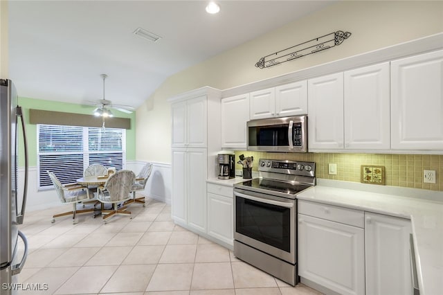 kitchen with tasteful backsplash, stainless steel appliances, vaulted ceiling, ceiling fan, and white cabinetry