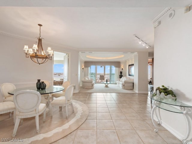 dining space featuring rail lighting, light tile patterned floors, a chandelier, and ornamental molding