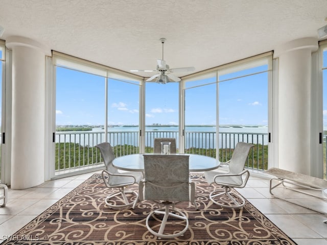 sunroom / solarium with a water view and ceiling fan