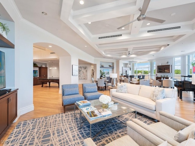 living room with light wood-type flooring, coffered ceiling, ceiling fan, crown molding, and beam ceiling