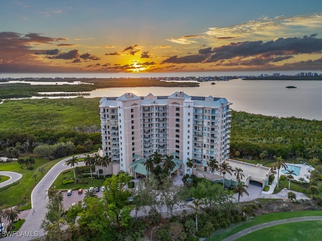 aerial view at dusk featuring a water view