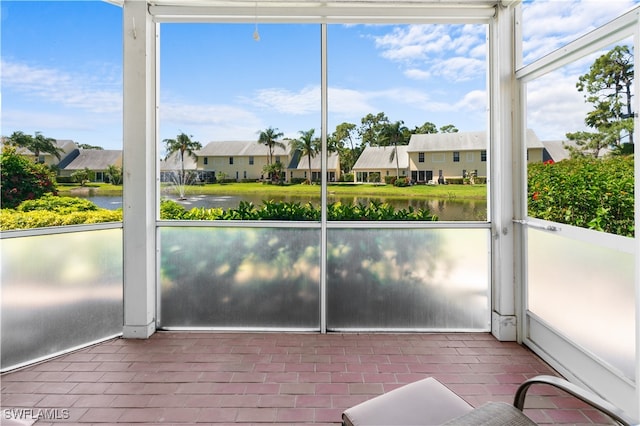 unfurnished sunroom featuring a water view