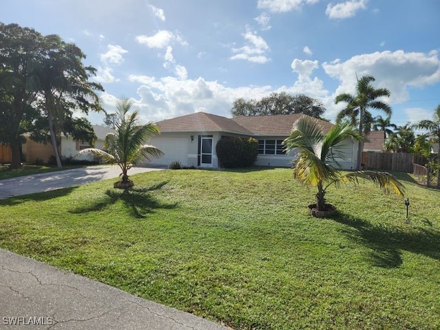 ranch-style house with fence, an attached garage, stucco siding, a front yard, and concrete driveway