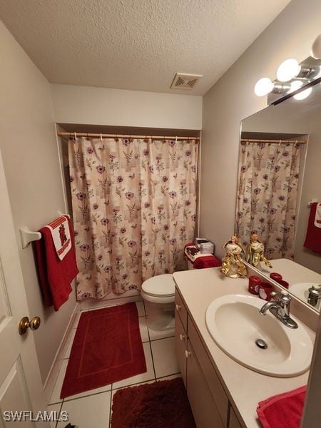 bathroom featuring tile patterned flooring, vanity, a textured ceiling, and toilet