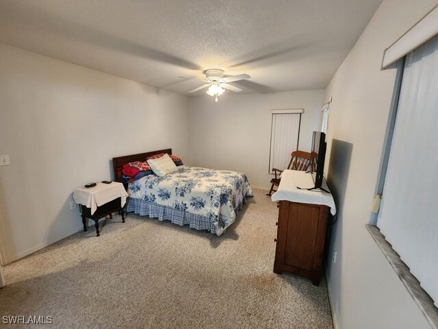 carpeted bedroom featuring a textured ceiling and ceiling fan