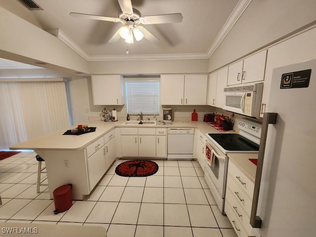 kitchen featuring sink, a kitchen breakfast bar, kitchen peninsula, white appliances, and white cabinets