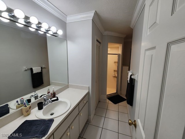 bathroom with tile patterned floors, a shower, a textured ceiling, ornamental molding, and vanity