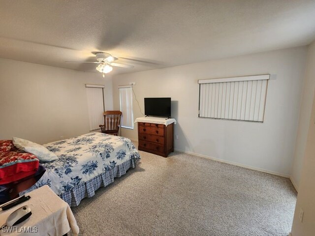 bedroom with ceiling fan, light colored carpet, and a textured ceiling