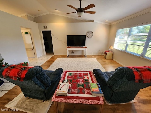 living room with vaulted ceiling, ceiling fan, crown molding, and light hardwood / wood-style flooring