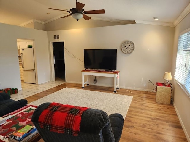 living room with lofted ceiling, ornamental molding, light hardwood / wood-style floors, and ceiling fan