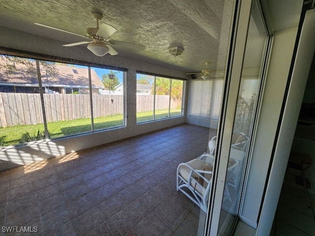 unfurnished sunroom with ceiling fan