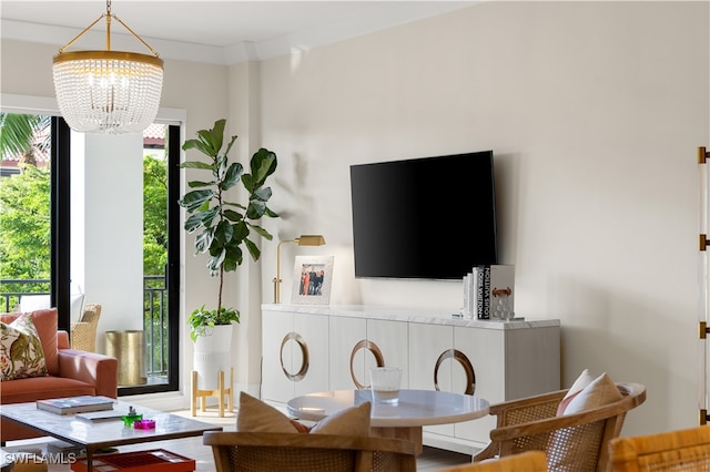 living room with hardwood / wood-style flooring, crown molding, and a chandelier