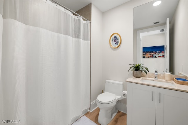 bathroom with hardwood / wood-style floors, vanity, and toilet