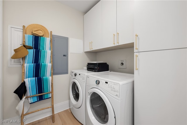 washroom with electric panel, separate washer and dryer, cabinets, and light wood-type flooring