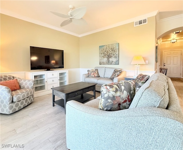 living room with wood-type flooring, ceiling fan, and crown molding