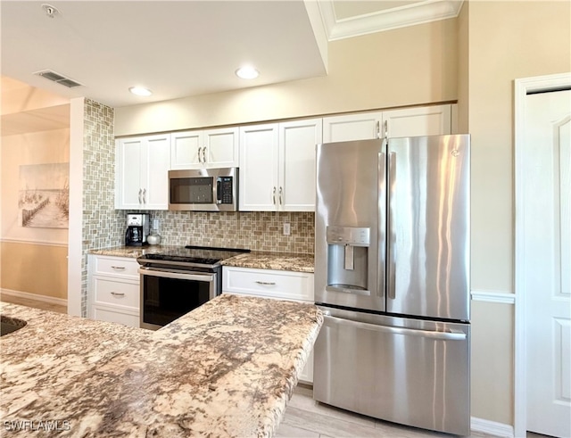 kitchen featuring tasteful backsplash, light stone counters, white cabinets, and stainless steel appliances