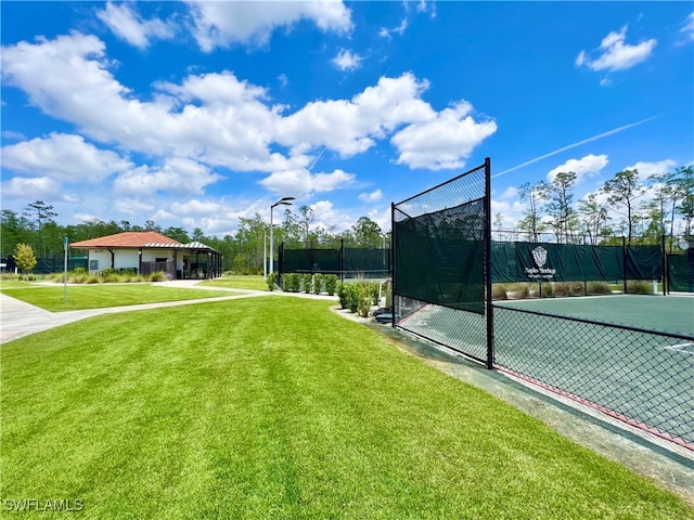 view of sport court with a yard