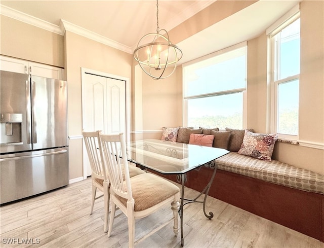 dining room featuring crown molding, plenty of natural light, light hardwood / wood-style floors, and a notable chandelier