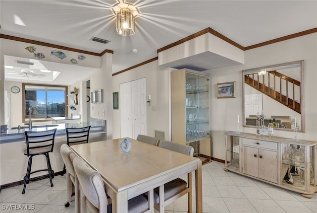 tiled dining area featuring a skylight, ornamental molding, and sink