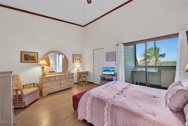 bedroom featuring access to outside, multiple windows, light hardwood / wood-style flooring, and high vaulted ceiling