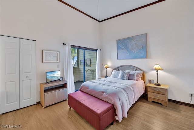 bedroom featuring ornamental molding, access to outside, light hardwood / wood-style flooring, a high ceiling, and a closet