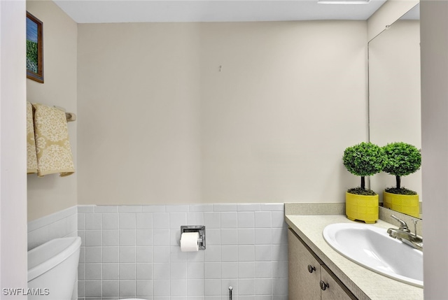 bathroom featuring vanity, toilet, and tile walls