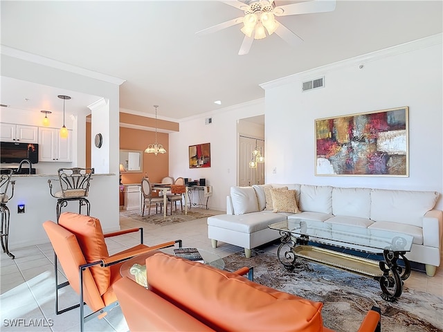 tiled living room featuring ceiling fan with notable chandelier and ornamental molding