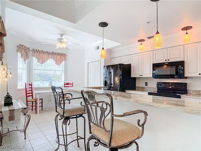 kitchen with black appliances, white cabinets, light stone countertops, and ornamental molding