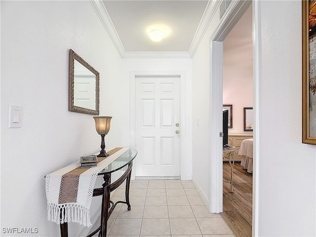 foyer with crown molding and light tile patterned flooring